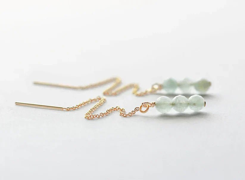 Aquamarine bead threader earrings with gold chain on a white background