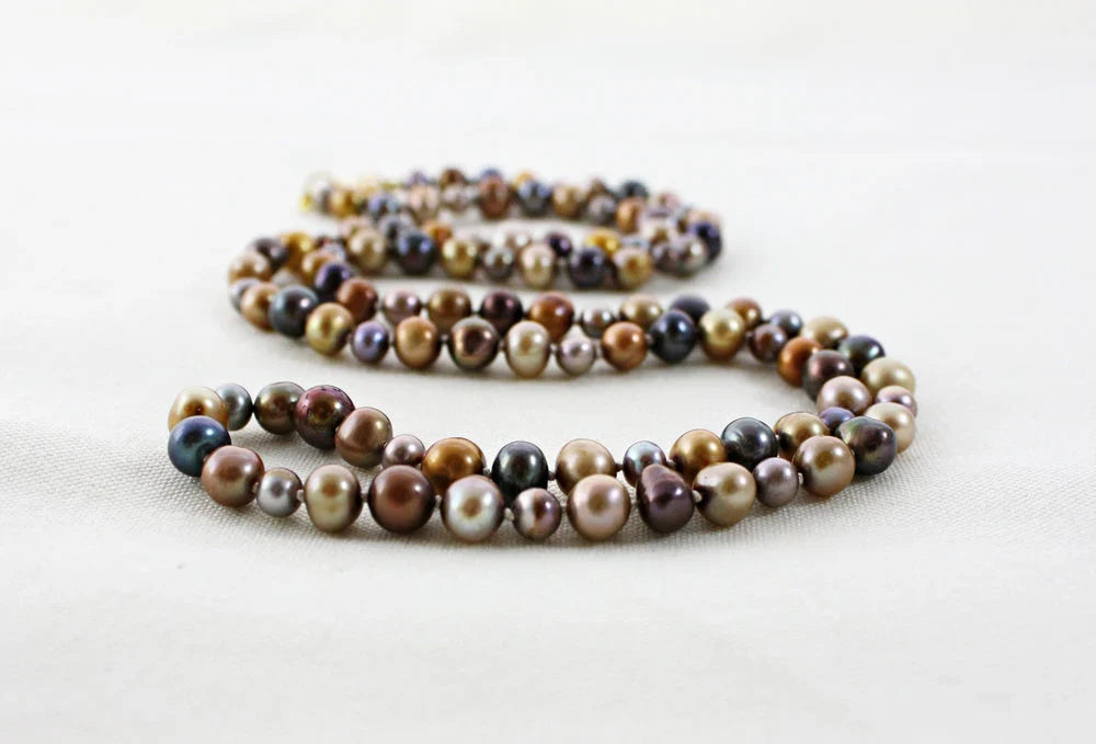 pearl necklace with multicolored brown and black beads on a white background.