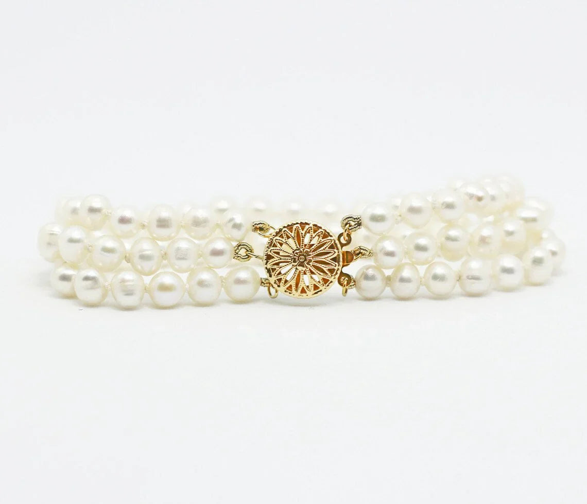 White pearl bracelet with gold  on a white background
