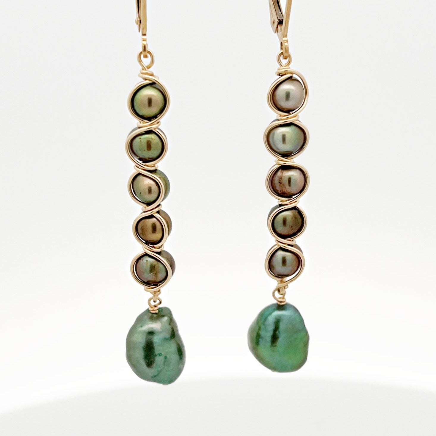 Pair of pearl earrings with gold accents on a white background