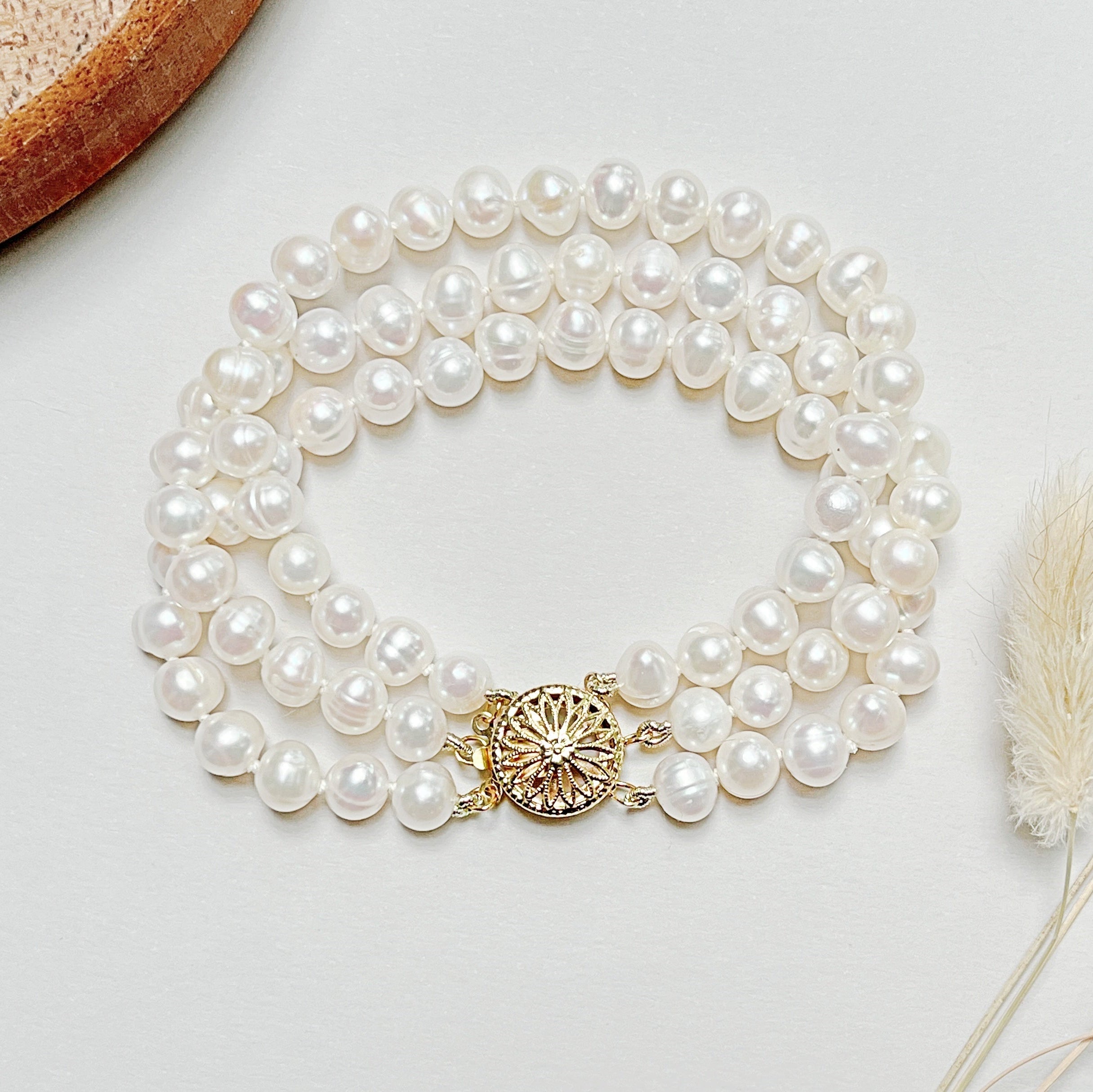 Freshwater pearl bracelet laying flat on a white table.