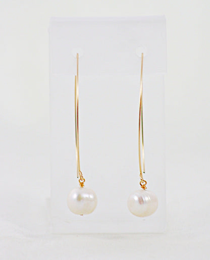 A pair of French Wire Pearl Earrings on a display stand.